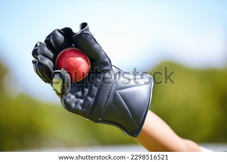 Cricket, ball and hand with a wicket keeper making a catch during a sports game outdoor on a pitch. Fitness, glove and caught with a sport player playing a competitive match outside during summer Royalty-Free Stock Photo #2298516521