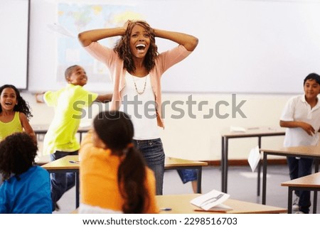 Stress, teacher shouting and black woman in classroom with children running around. Education, headache and female person screaming with burnout, tired or fatigue with kids in busy class at school. Royalty-Free Stock Photo #2298516703