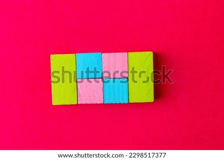 Multi-Colored Building Blocks on pink background.