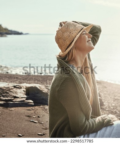 Loving the lakeside living. a young woman spending a day at the lake. Royalty-Free Stock Photo #2298517785