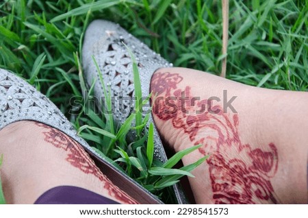 Red art women legs in the green grass