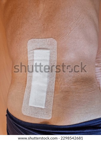 Big plaster on men's back after spine operation - herniated discs surgery
