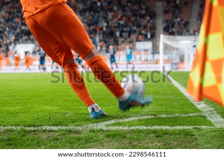 Footballer takes the corner. Detail of player's legs and the ball during soccer match. Royalty-Free Stock Photo #2298546111