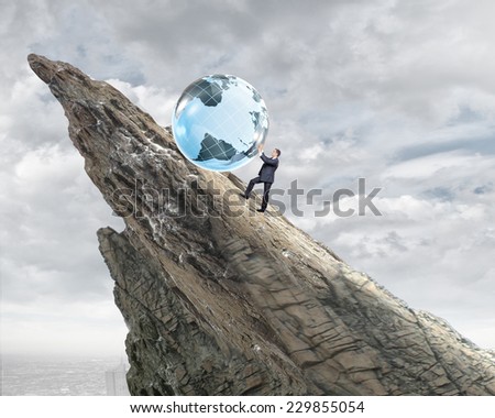 Young businessman rolling Earth planet up th hill