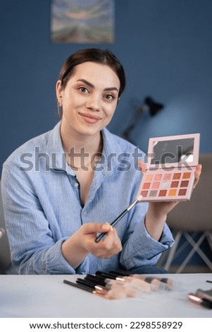 beautiful young female influencer talented blogger doing makeup, doing makeup reviews for vlog, giving advice to girls and women, filming the process on camera. webcam view Royalty-Free Stock Photo #2298558929