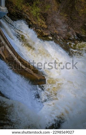 Sherbrooke Dam with overflowing water after spring rain storm at Magog River, downtown Sherbrooke, Quebec, Canada