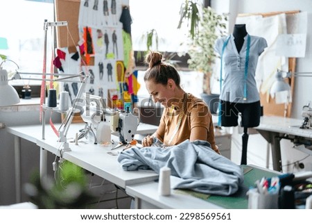 Fashion designer using a sewing machine at her workplace
