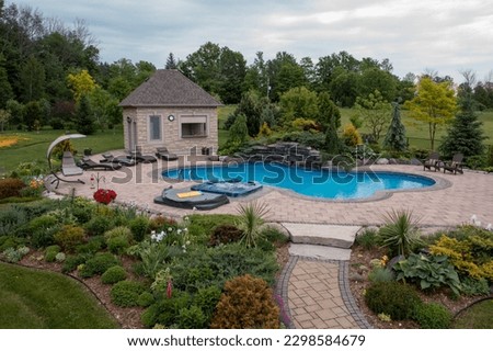 Experience resort-style living in this luxurious home featuring a stunning backyard oasis with a sparkling pool and lush garden. Perfect for entertaining and relaxation, the outdoor space. Royalty-Free Stock Photo #2298584679
