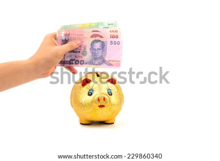 left hand holding thailand paper currency and piggy bank isolated on white