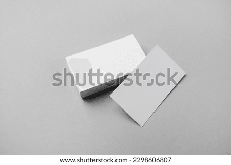 Blank white business cards on gray paper background. Mockup for branding identity.
