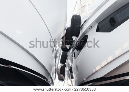 Two luxury motor yachts huddled together on fenders. Royalty-Free Stock Photo #2298610353