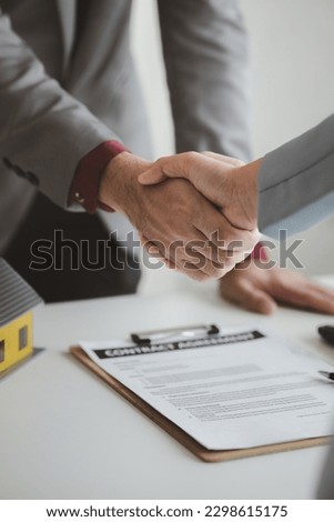 Housing estate agents shake hands with customers after a deal is completed, explaining and presenting information about homes and purchasing loans. Real estate trading concept.