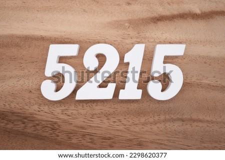 White number 5215 on a brown and light brown wooden background.