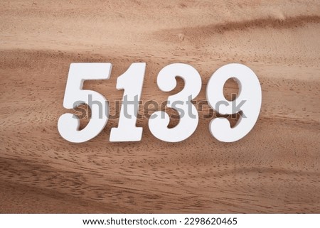 White number 5139 on a brown and light brown wooden background.