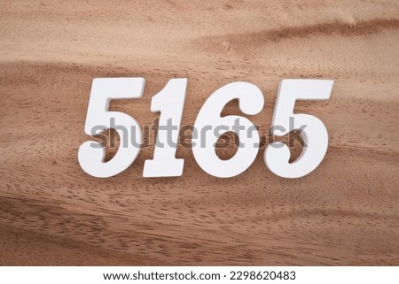 White number 5165 on a brown and light brown wooden background.