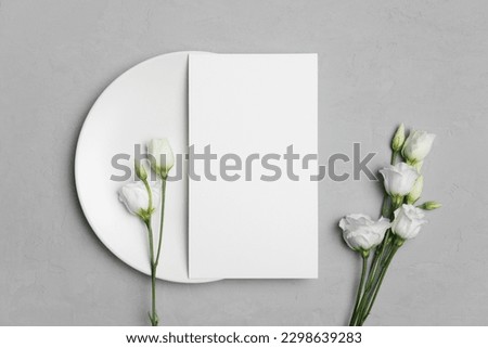 Wedding menu card mockup on white plate with eustoma flowers, blank mockup with copy space