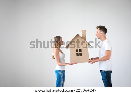 Happy couple with cardboard house
