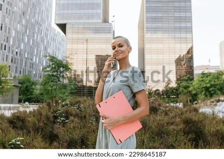 Powerful Female Leader with Short Hair Holding Folder Royalty-Free Stock Photo #2298645187