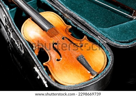small model of an old violin with bag on black surface with black background