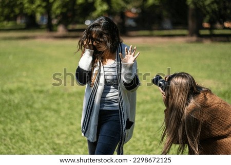 Woman rejecting paparazzi. Photographer trying to get a picture of person who refuses