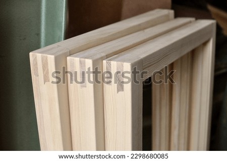 Detail and close up of window frame bridle joint. Three new pine wooden window frame are ready for painting. Royalty-Free Stock Photo #2298680085