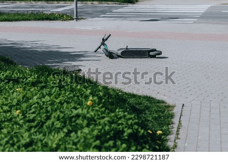 overturned scooter on the sidewalk  Royalty-Free Stock Photo #2298721187