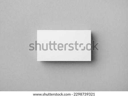 Blank business card on gray paper background. Mock-up for branding identity. Flat lay.