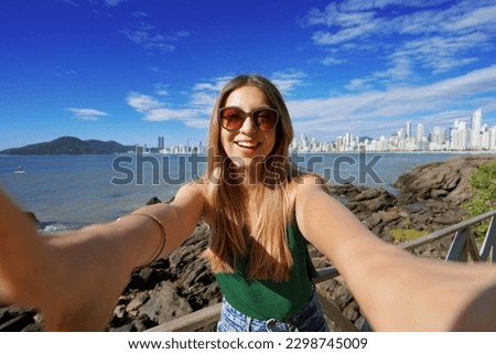 Trendy millennial girl having fun takes self portrait on summer vacation in Balneario Camboriu, Brazil Royalty-Free Stock Photo #2298745009