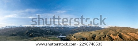 Aerial view of the Tian Shan hills and mountains captures the striking ruggedness and beauty of the region. Stunning panoramic view shows rolling hills and towering peaks