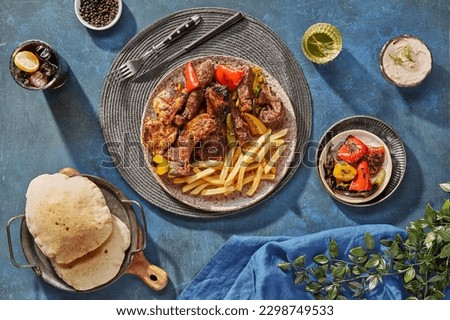 Middle Eastern or Arabic cuisine with a variety of mezze on a rustic concrete backdrop Food that is Halal. Cuisine from Lebanon, Turkey, and Egypt, with mixed veggies and a gorgeous table top view Royalty-Free Stock Photo #2298749533