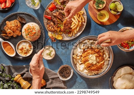 Middle Eastern or Arabic cuisine with a variety of mezze on a rustic concrete backdrop Food that is Halal. Cuisine from Lebanon, Turkey, and Egypt, with mixed veggies and a gorgeous table top view Royalty-Free Stock Photo #2298749549