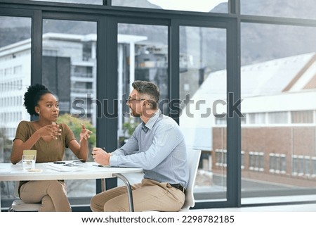 Business people, meeting and talking or planning in an office with city building background. A man and woman together at table for diversity, brainstorming and collaboration or partnership discussion