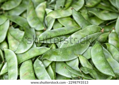 Close-up on a stack of Avaraikai (Broad Beans) on a market stall.