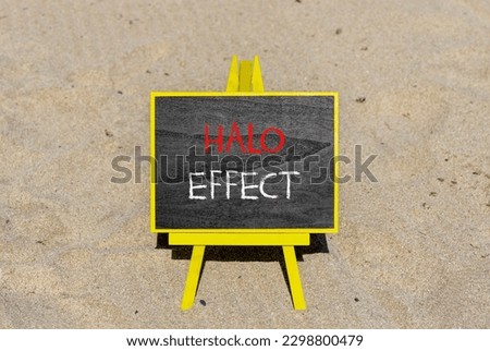 Halo effect and psychological symbol. Concept words Halo effect on beautiful black chalk blackboard on a beautiful sand beach background. Business psychological and Halo effect concept. Copy space.