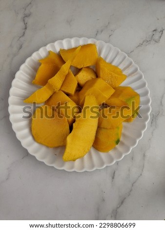 Close up of famous sweet mango in North Malaysia called Harum Manis isolated on top of wooden background. Sweet and juicy. Malaysian and Asian favourite mango.