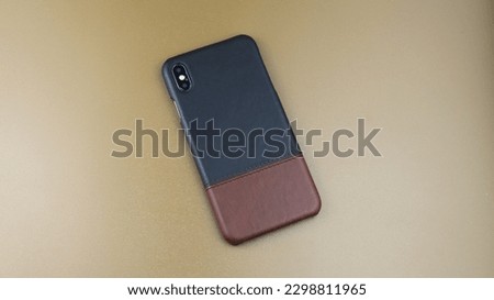 High angle view of multicolored leather mobile phone cases. Isolated on brown background. Product catalogue for business advertisement.