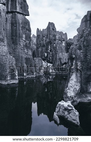 Gorgeous black limestone rocks of Shilin Stone Forest, Kunming, Yunnan, China. A part of the UNESCO'S World Heritage site South China Karst. Part with the pond, reflection in water