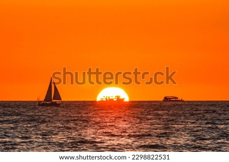 silhouettes of boats and ships at sunset with sun behind in puerto vallarta jalisco  Royalty-Free Stock Photo #2298822531