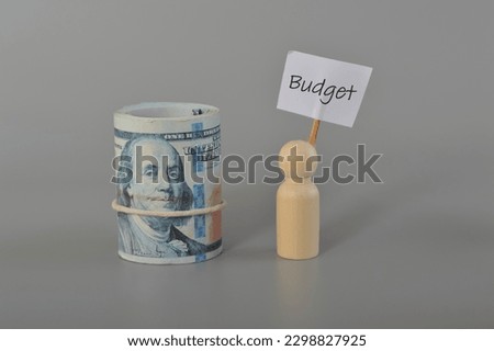 Money banknotes and wooden figure with text BUDGET.