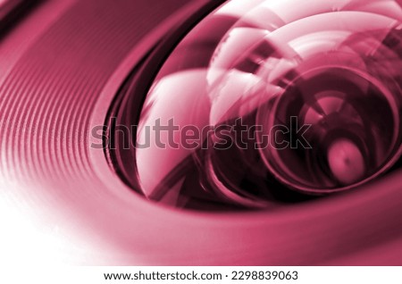 Photo Camera or Video lens close-up, objective concept of photographer or camera man job, looking for a photographer, journalist Image toned in Viva Magenta, color of the 2023 year