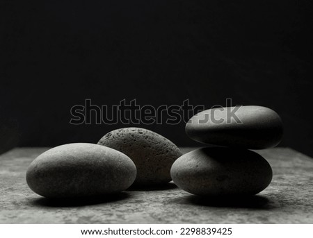 gray zen stones on a dark gray background with shadows for a podium background.a group of oval stones for product presentation