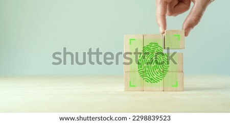 Fingerprint scanning identification system. Biometric authorization and personal security. Green fingerprint with green transparency light on wooden cube blocks on clear background and copy space. Royalty-Free Stock Photo #2298839523