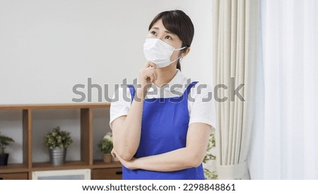 Asian female cleaner with apron Royalty-Free Stock Photo #2298848861