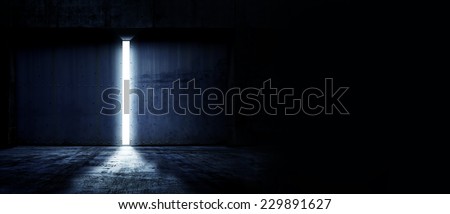 Heavy steel doors opening. Large steel doors of an hanger like building opening and light coming in. with copyspace Royalty-Free Stock Photo #229891627