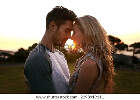 Sunset, love or couple in nature on romantic holiday vacation for bonding or relaxing on date together. Forehead, travel or people hug or embrace in summer with romance or peace in park in the dark Royalty-Free Stock Photo #2298919111