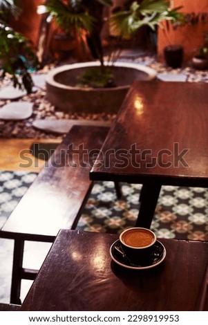 Coffee cup on wooden table in retro cafe interior.