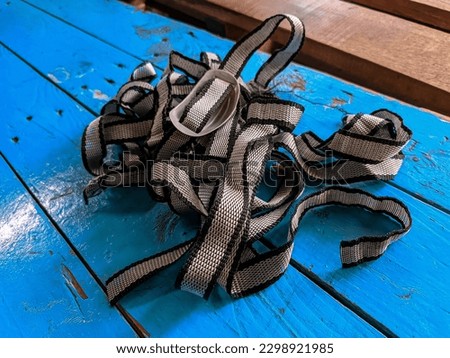 Photo of a stack of work helmet chin straps with a blue background