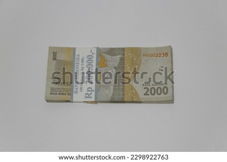 Stack of 2000 IDR (Indonesian Rupiah) banknotes, isolated on white background