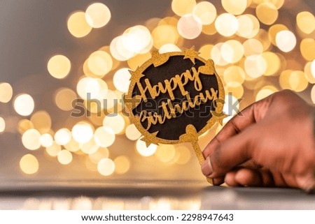 Happy birthday greeting image, person holding birthday card isolated on bokeh background