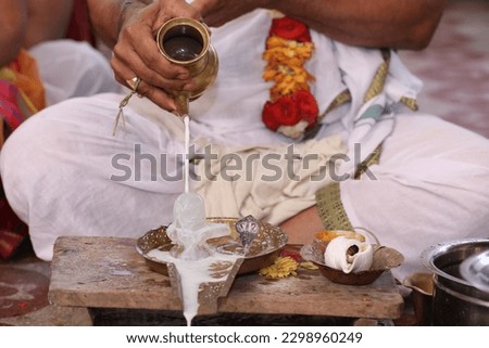 Performing Pooja for Hindu god siva linga with milk, honey and coconut water Royalty-Free Stock Photo #2298960249